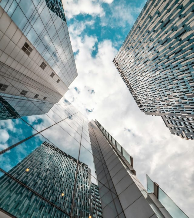 Low angle view of modern skyscrapers reflecting the cloudy sky in Brussels, Belgium.